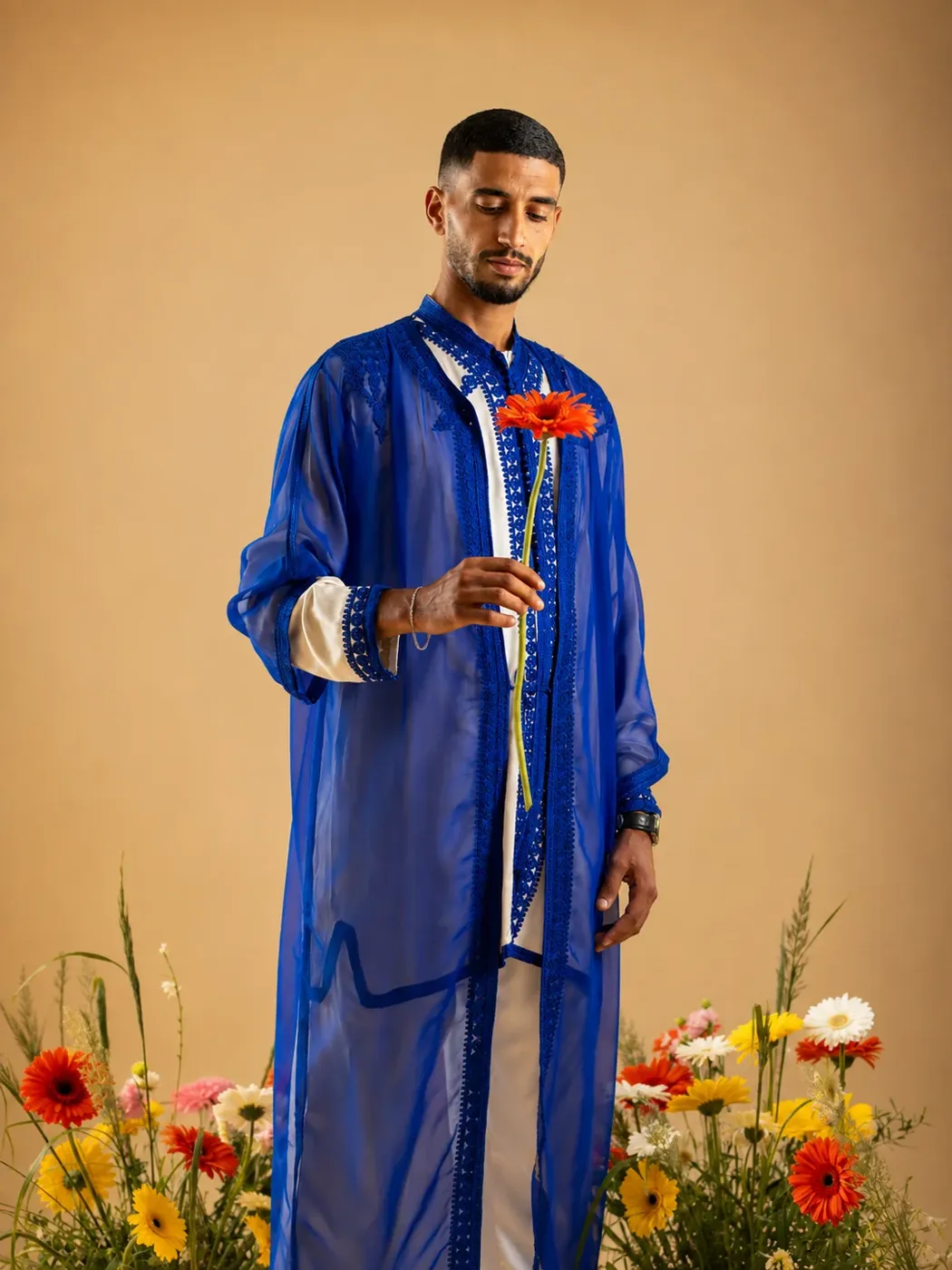 Marié en tenue bleue tenant une fleur, scène composée par le photographe de mariage