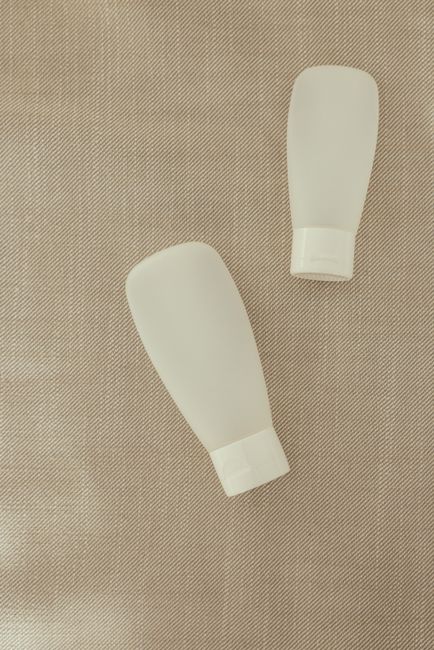 Packshot de flacons cosmétiques sur fond de lin neutre
